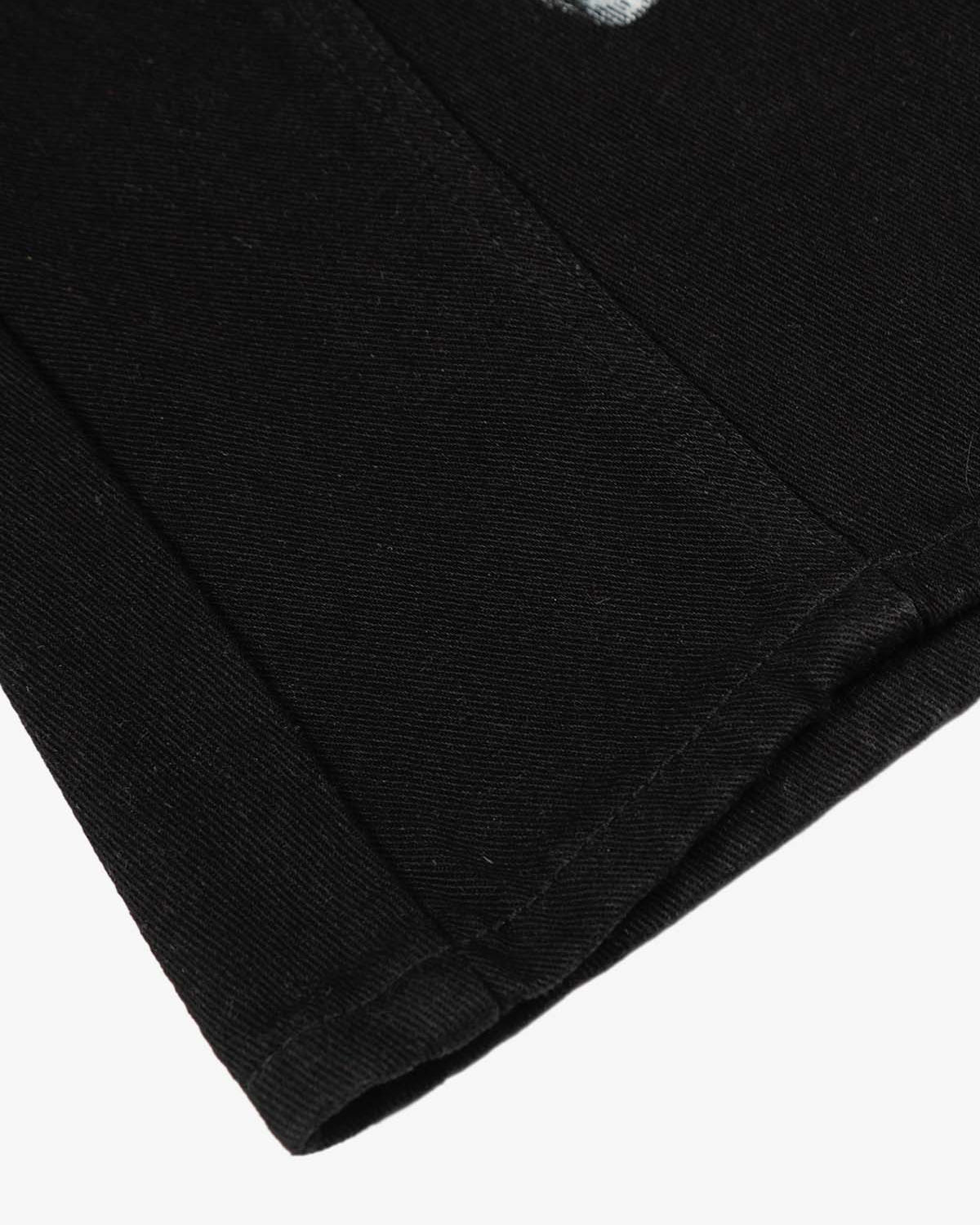 Close-up of Black Star Paint Baggy Jeans hem, showing twill weave, folded edge, and stitching, highlighting their oversized, artistic design and high-street aesthetic.