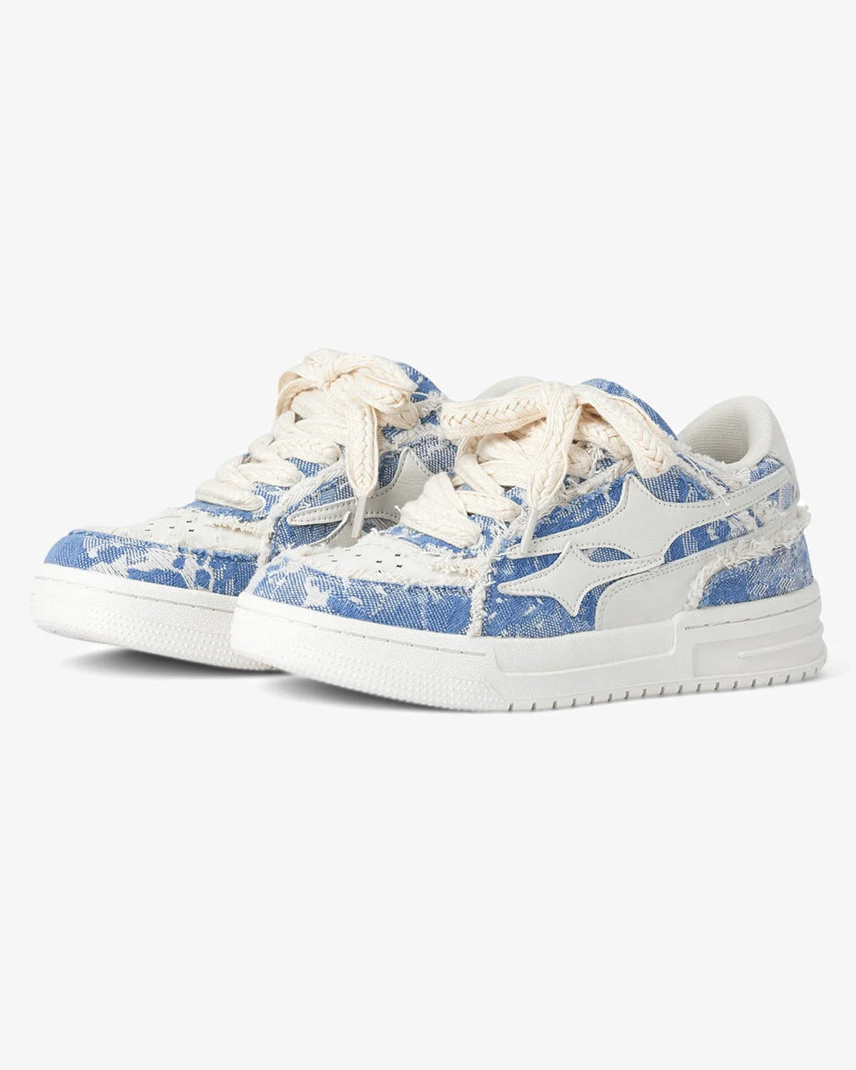 Distressed Denim Low-Top Street Sneakers with frayed blue-and-white denim uppers, thick white soles, cream laces, and a white leather logo appliqué on side panels.
