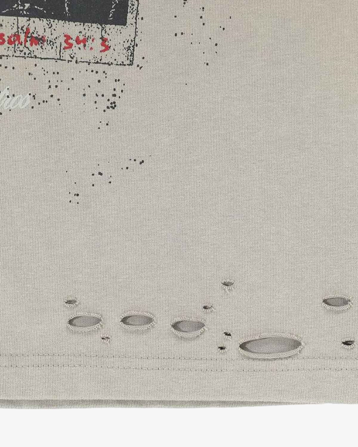 Distressed Grunge Layered T-Shirt close-up showing a speckled graphic, distressed holes, and hem, embodying vintage street style with a worn-in look.