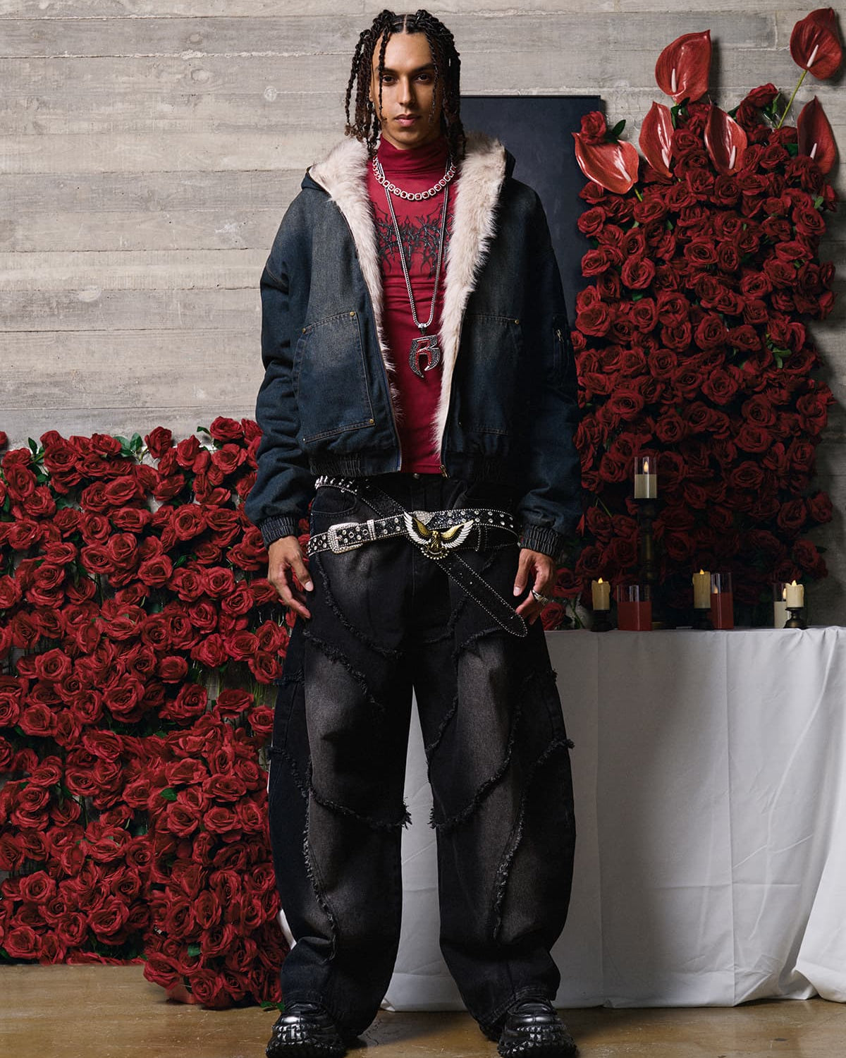 Young man models the Distressed Washed Faux Fur Winter Jacket, showcasing its rugged denim texture and luxurious faux-fur lining against a floral backdrop.