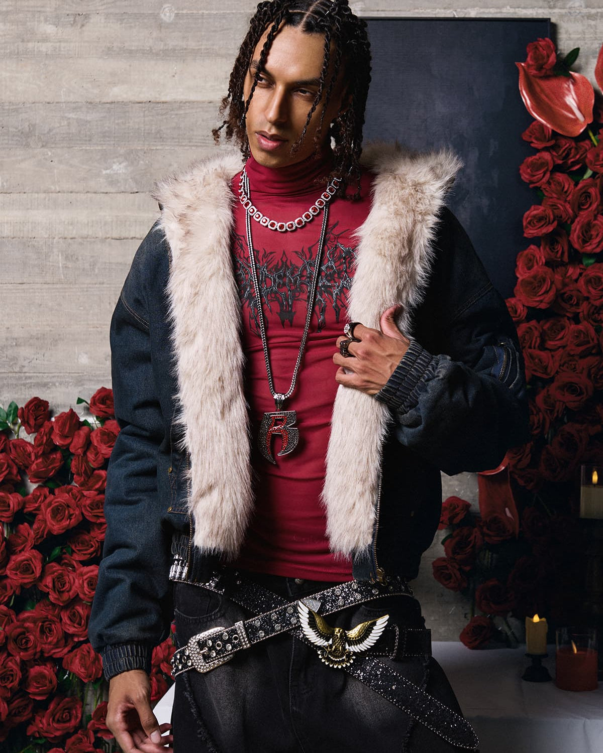 Model wearing Distressed Washed Faux Fur Winter Jacket with tan faux fur collar, layered over a red mock-neck top, complemented by layered chains and rings.