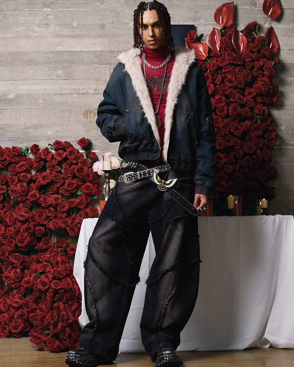 Young male model in a Distressed Washed Faux Fur Winter Jacket, showcasing its rugged texture and faux-fur lining, surrounded by candles and red roses.