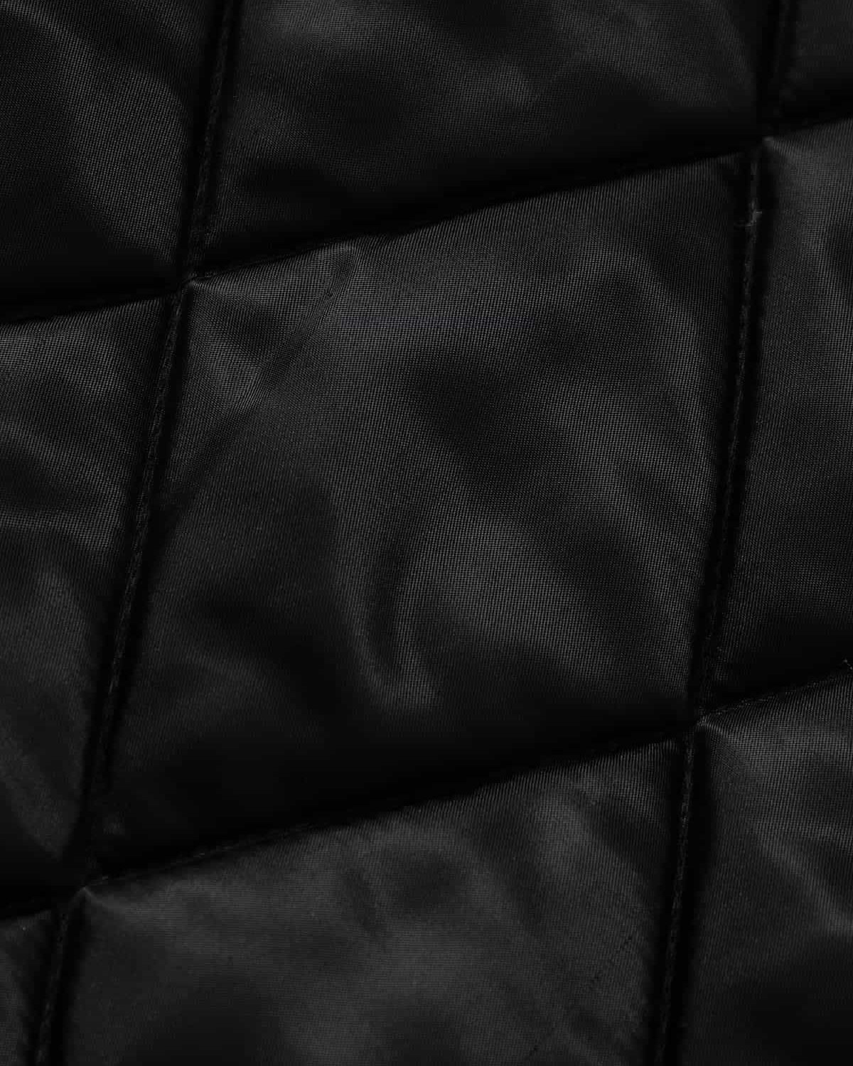 Graphic Graffiti High Neck Street Jacket featuring quilted black fabric with diagonal stitching, showcasing bold graffiti designs and a padded structure for a distinctive streetwear appeal.