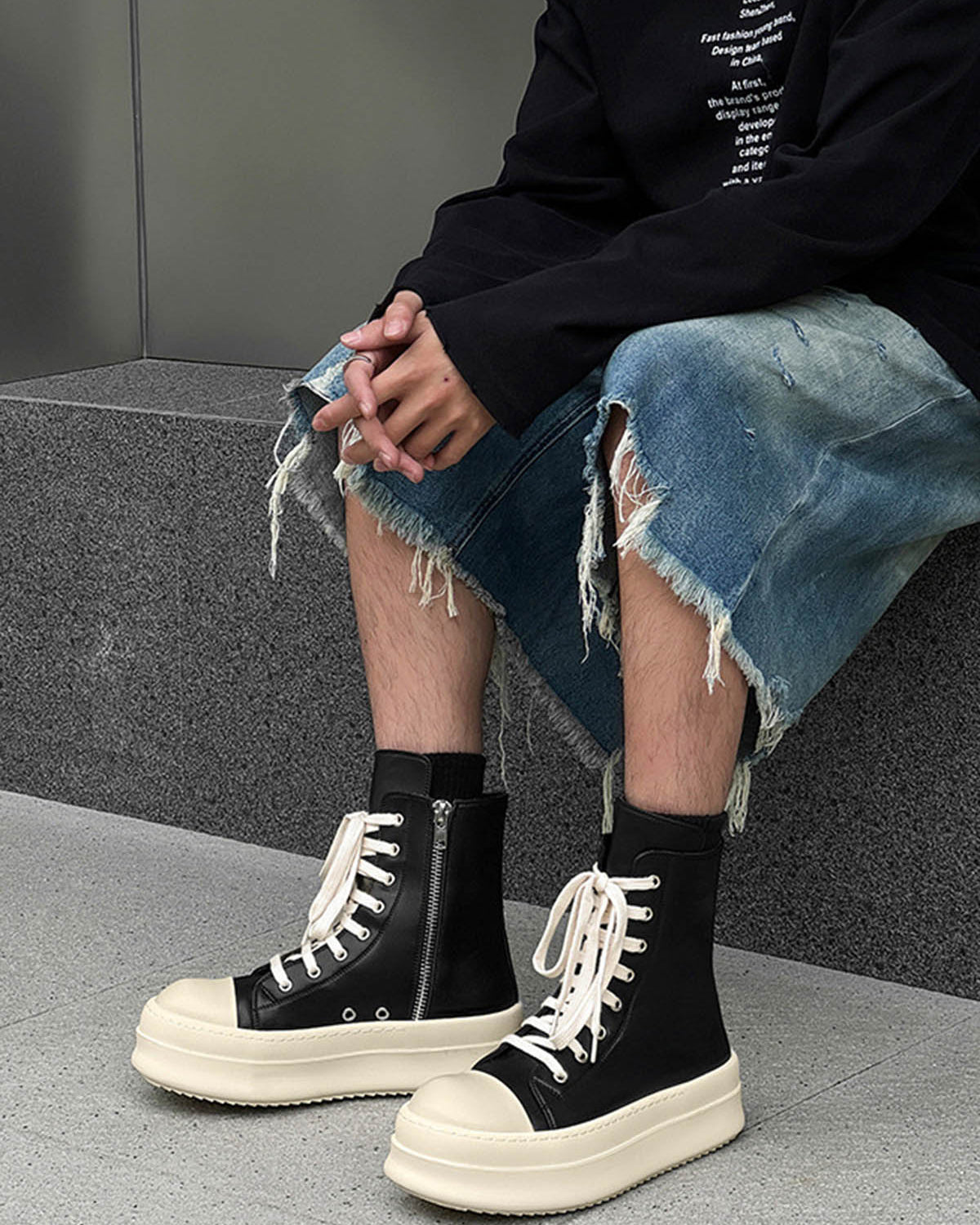 High-Top Platform Streetwear Sneakers with chunky off-white soles, black uppers, white laces, and side zipper, worn with distressed denim and black top.