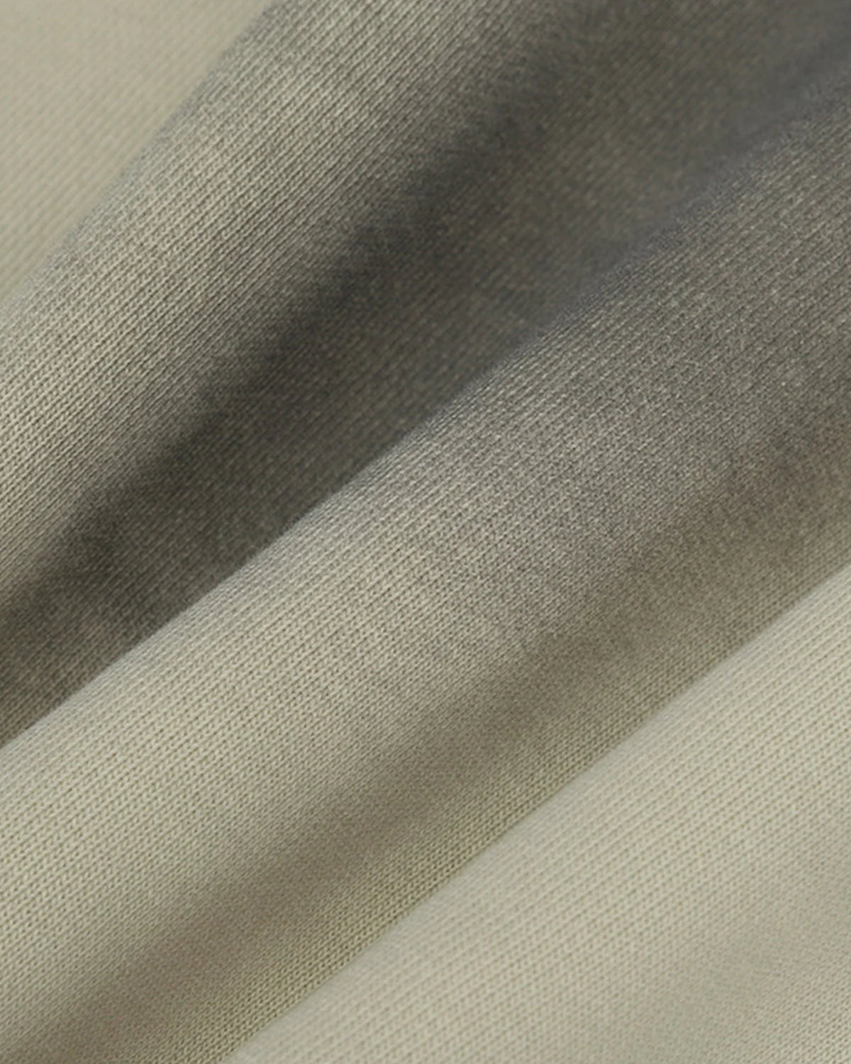 Close-up of Ink Dyed Raw-Edge Streetwear Hoodie showcasing its neutral-toned, woven fabric with visible texture, ink-dyed fading, and raw-edge detailing for an oversized, rugged look.