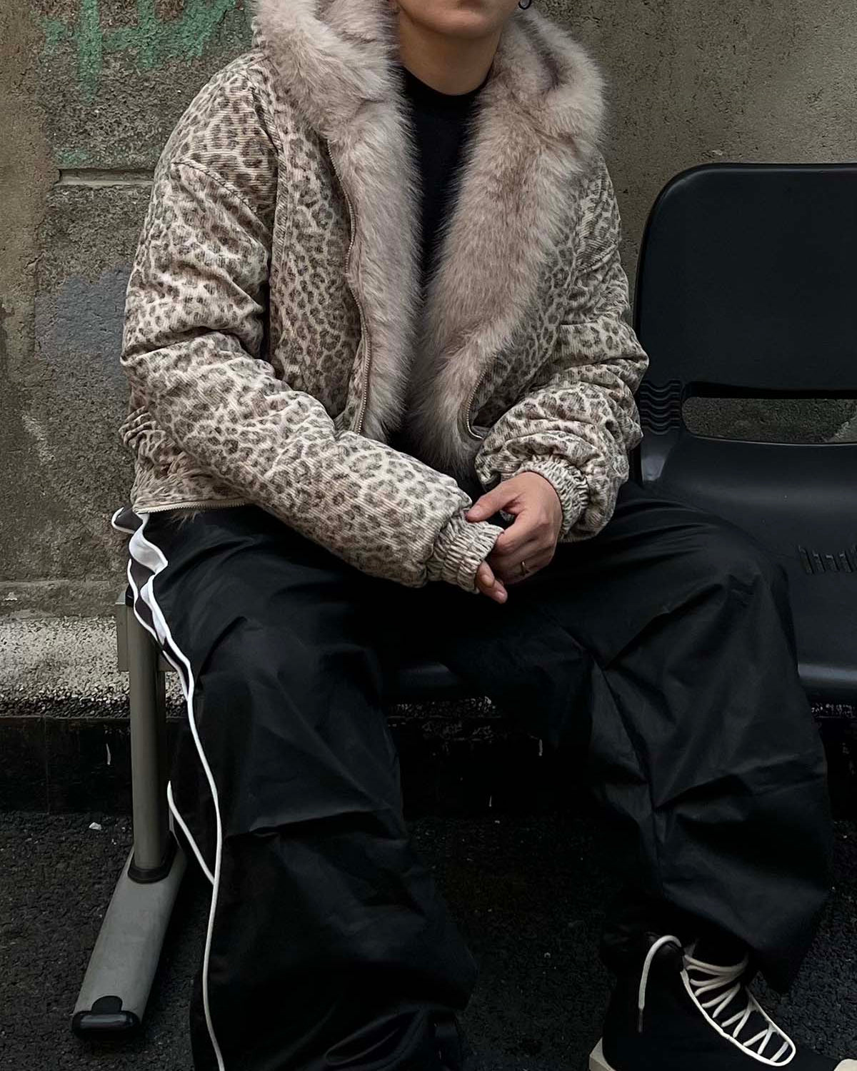 Leopard Faux Fur Hooded Jacket on seated person; features bold leopard print, fur-trimmed hood, relaxed fit, perfect for standout winter streetwear.