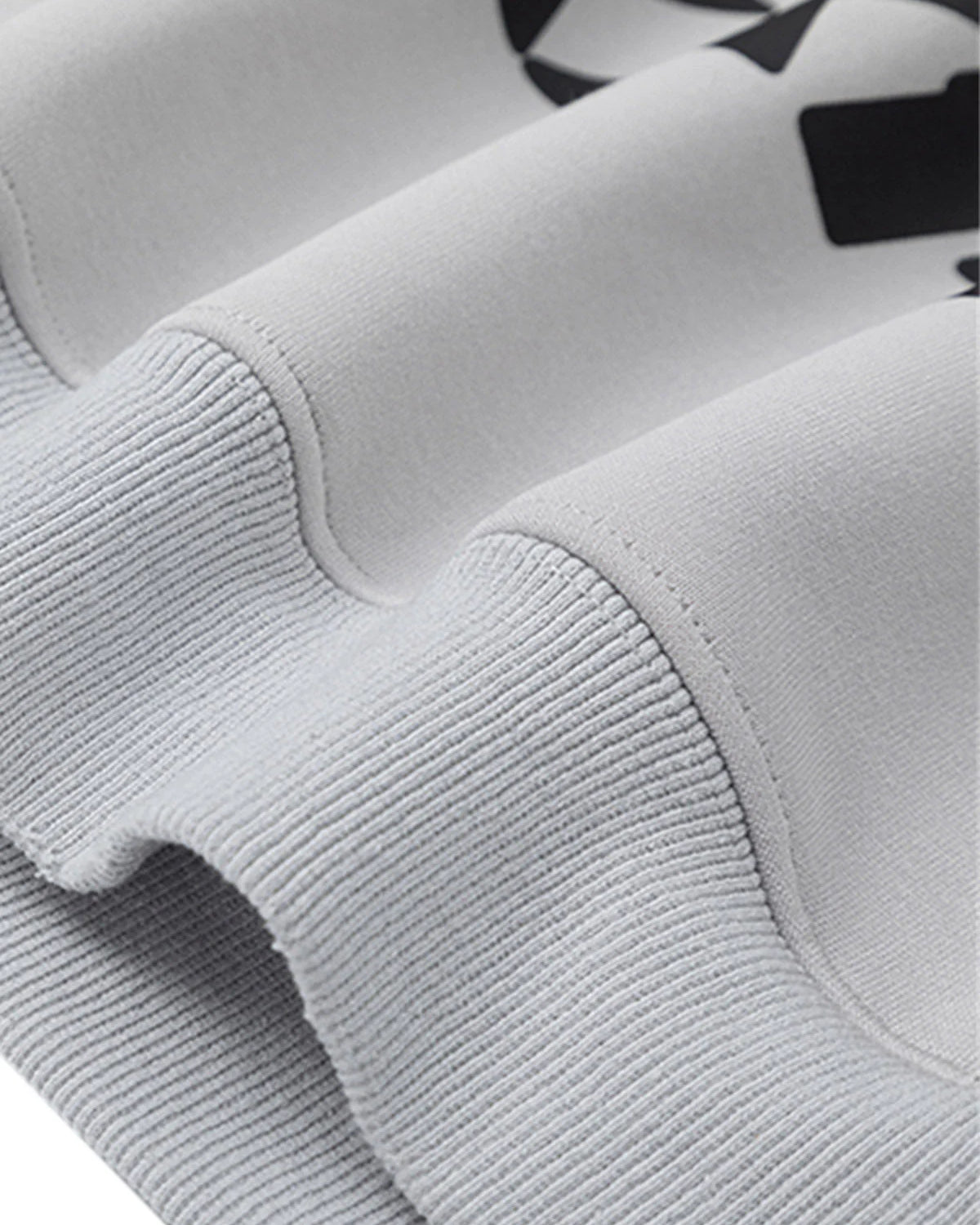 Close-up of Racing Graphic Distressed Streetwear Hoodie, featuring a rib-knit cuff, smooth body fabric, and partial black racing-inspired artwork above the seam.