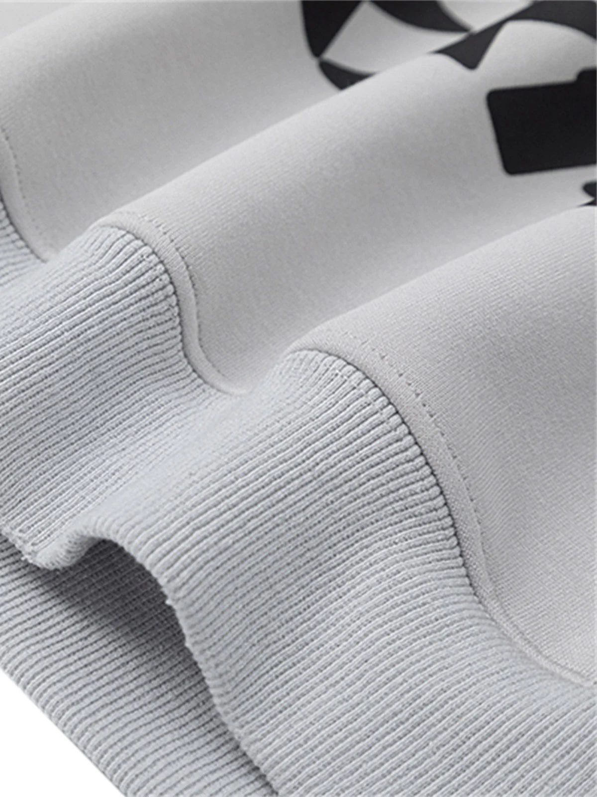 Close-up of Racing Graphic Distressed Streetwear Hoodie, featuring a rib-knit cuff, smooth body fabric, and partial black racing-inspired artwork above the seam.