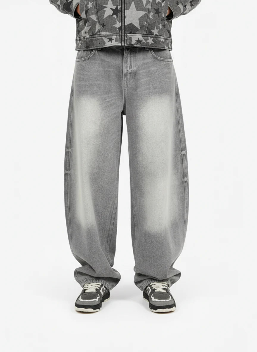 Retro Washed Grey Baggy Jeans with a wide curved-leg silhouette, faded effect on thighs and knees, styled with black-and-white sneakers for a vintage streetwear look.