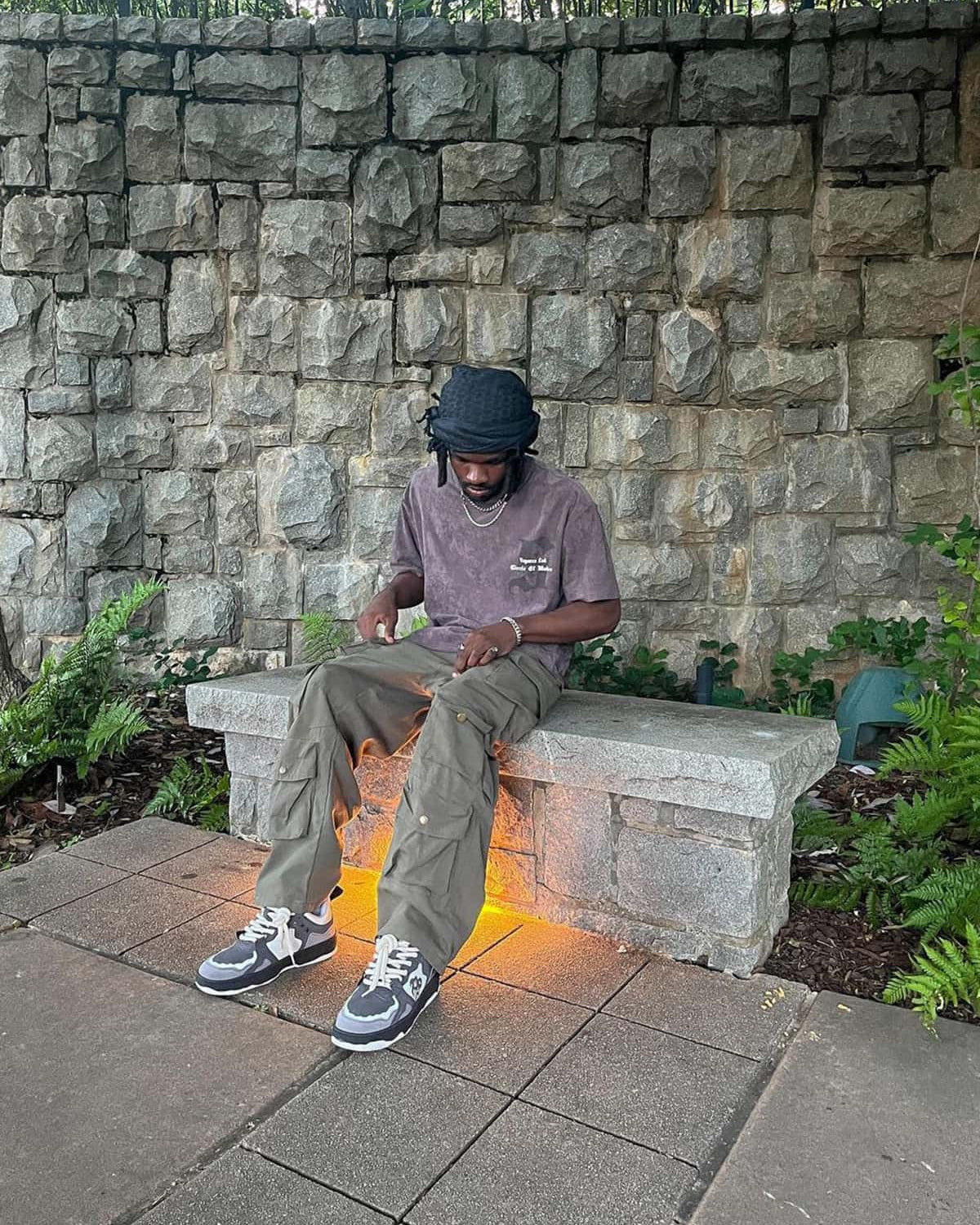 Man on bench wearing Vintage Chunky Graphic Skate Shoes with bold graphics, chunky silhouette, and thick laces, casting warm glow from under-bench light.