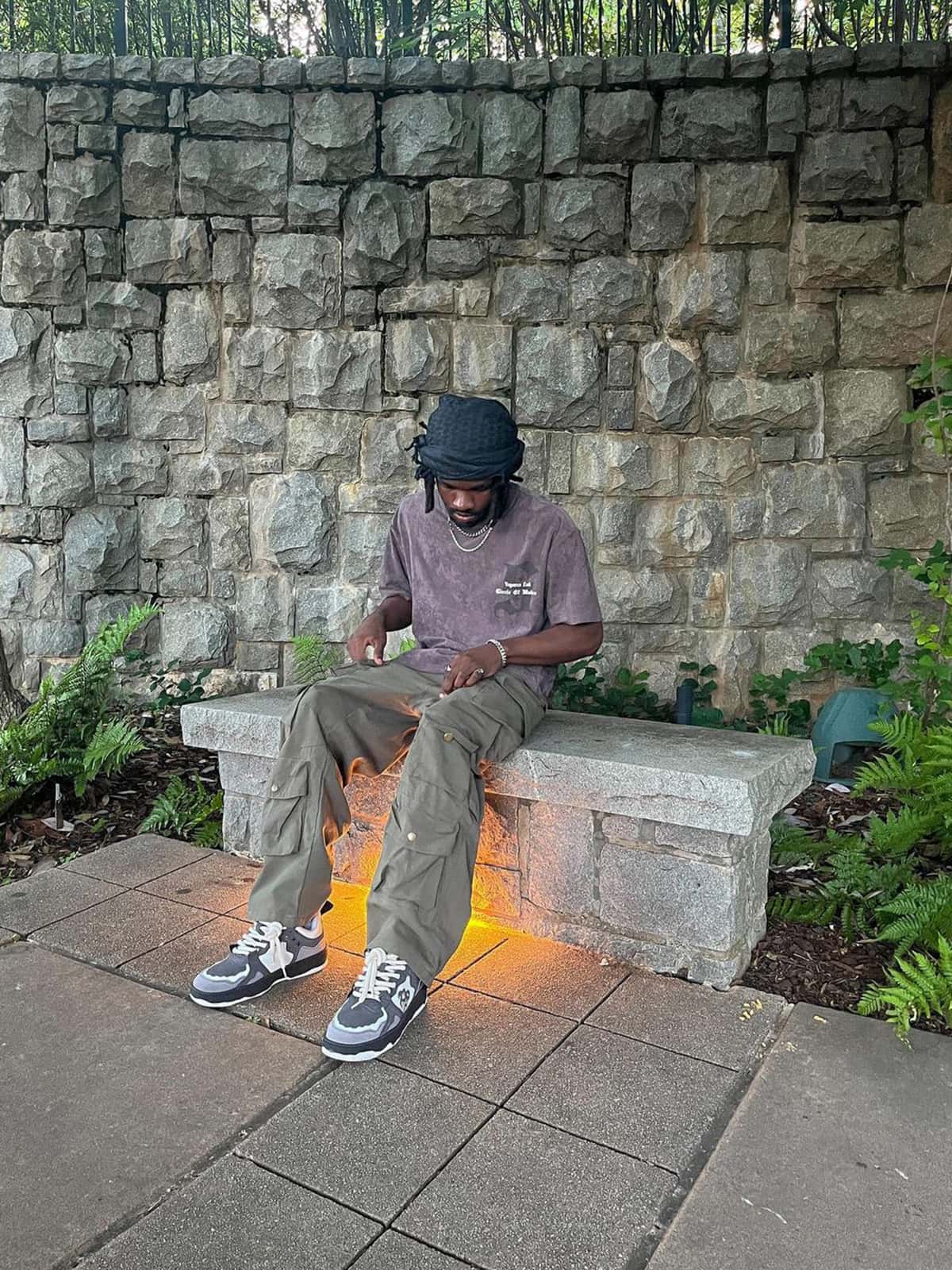 Man on bench wearing Vintage Chunky Graphic Skate Shoes with bold graphics, chunky silhouette, and thick laces, casting warm glow from under-bench light.