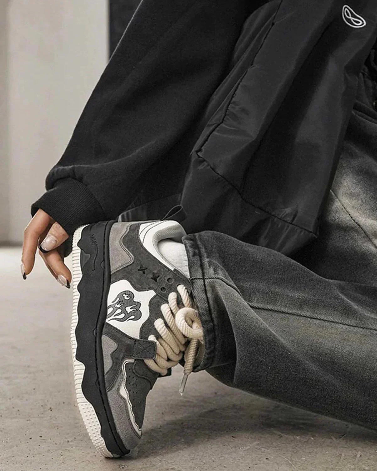 Vintage Chunky Graphic Skate Shoes with flame-like motifs, thick rope laces, and a low-top silhouette, paired with cuffed grey jeans and white socks.