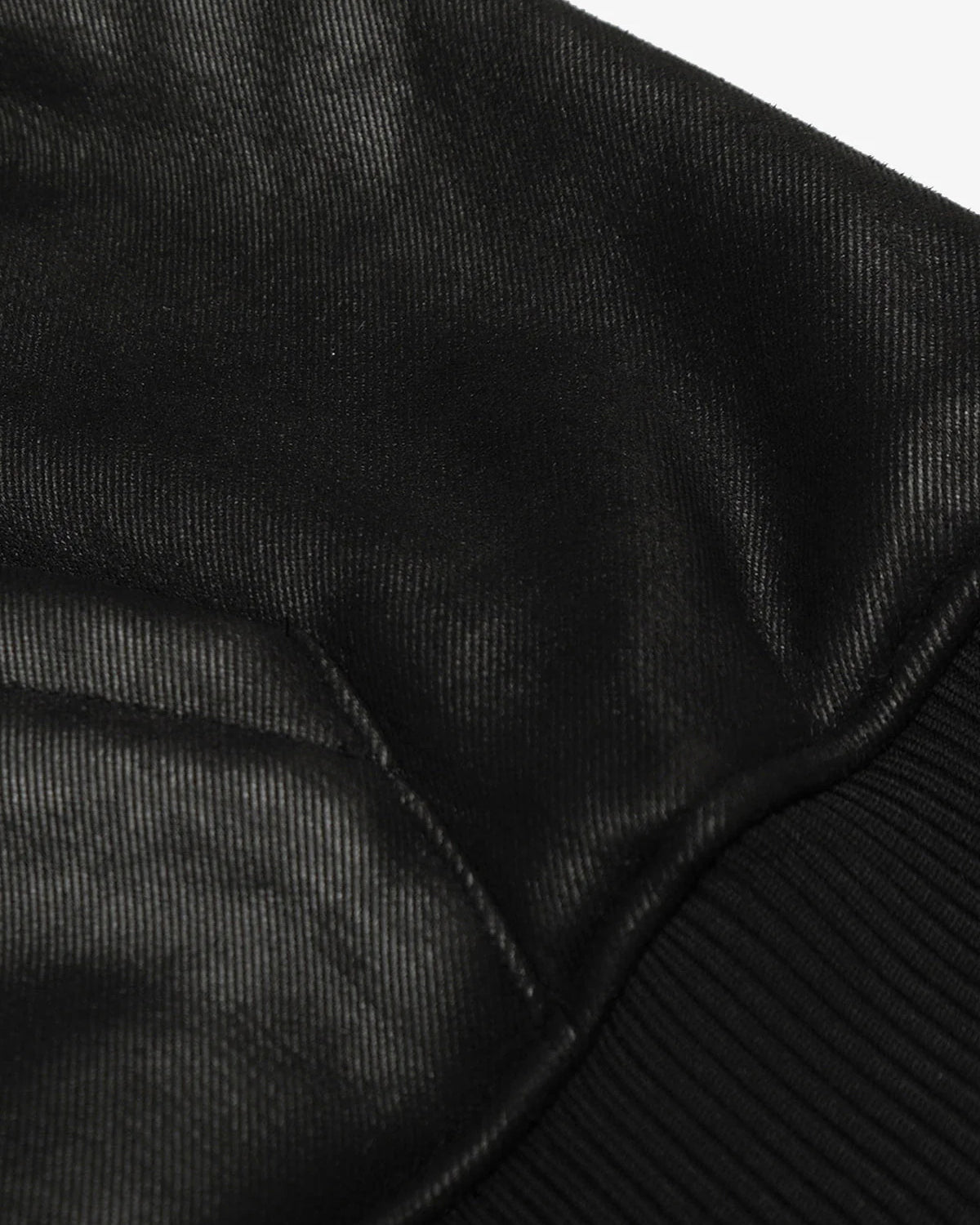 Close-up of the Vintage Hooded Leather-Look Street Jacket, showcasing its leather-look finish, ribbed cuff, and stitched seam, highlighting its bomber-style sleeve design.