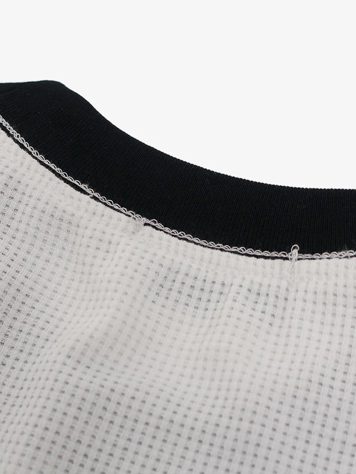 Close-up of the Vintage Waffle Graphic Long-Sleeve T-Shirt's neckline, featuring a waffle-knit texture and black rib-knit collar with visible overlock stitching.