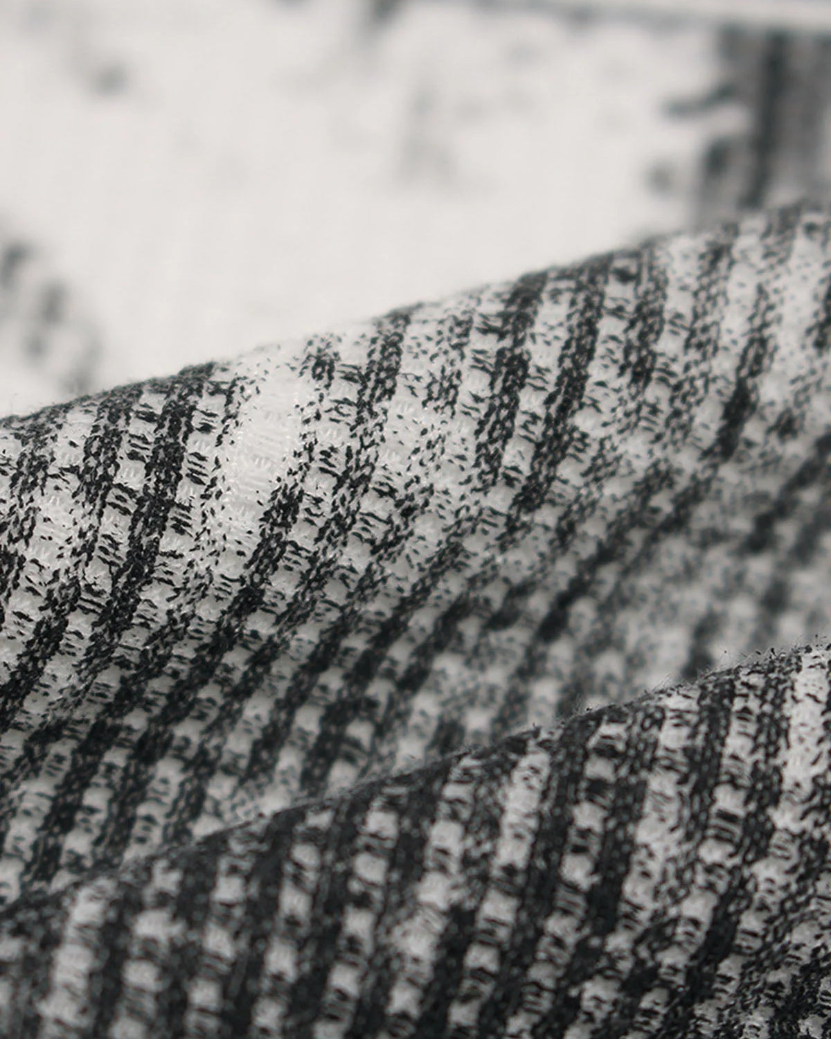 Close-up of textured black-and-white striped fabric from the Vintage Waffle Graphic Long-Sleeve T-Shirt, showcasing its unique knit pattern and retro streetwear vibe.