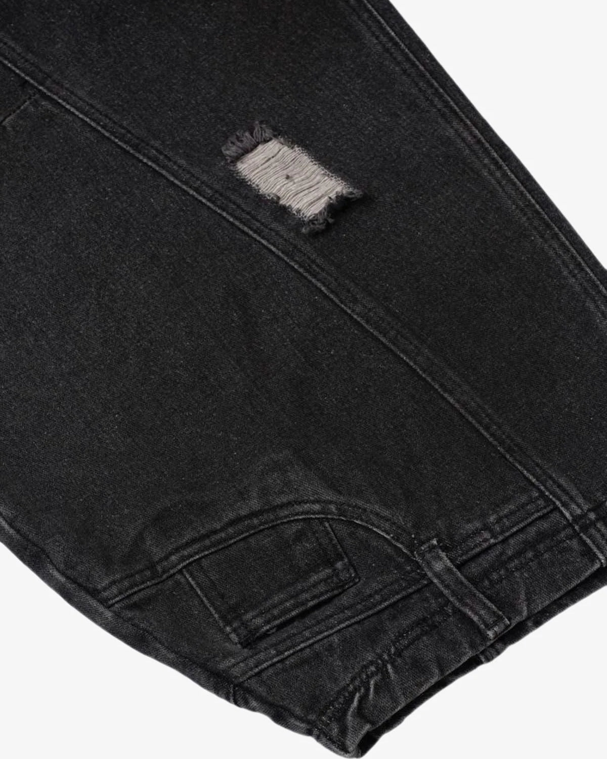 Close-up of Vintage Washed Baggy Ripped Jeans showcasing a distressed patch above the knee, emphasizing the oversized, relaxed streetwear silhouette.