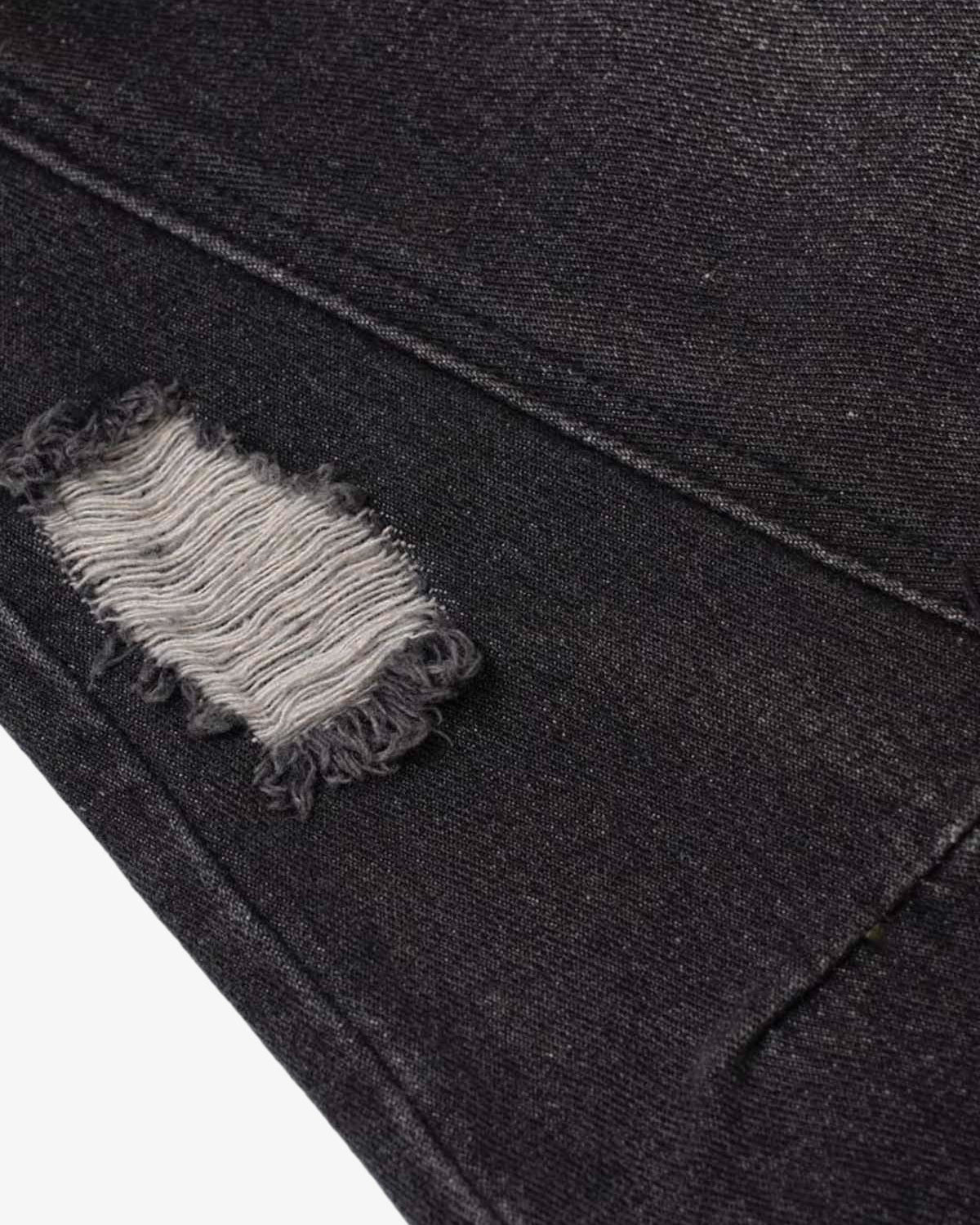 Close-up of Vintage Washed Baggy Ripped Jeans showing a distressed patch with frayed edges, revealing lighter threads, highlighting their grunge-inspired, oversized streetwear design.