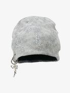 Distressed Charm Knit Hat with a light-gray ribbed knit, featuring intentional distressing, a dangling silver-tone charm, and a slouchy, grunge-inspired design.