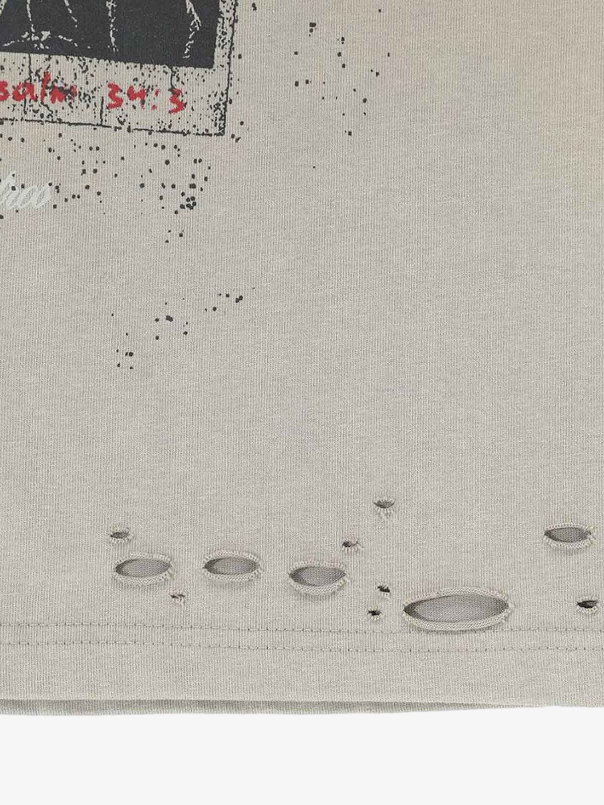 Distressed Grunge Layered T-Shirt close-up showing a speckled graphic, distressed holes, and hem, embodying vintage street style with a worn-in look.