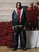 Young man models the Distressed Washed Faux Fur Winter Jacket, showcasing its rugged denim texture and luxurious faux-fur lining against a floral backdrop.