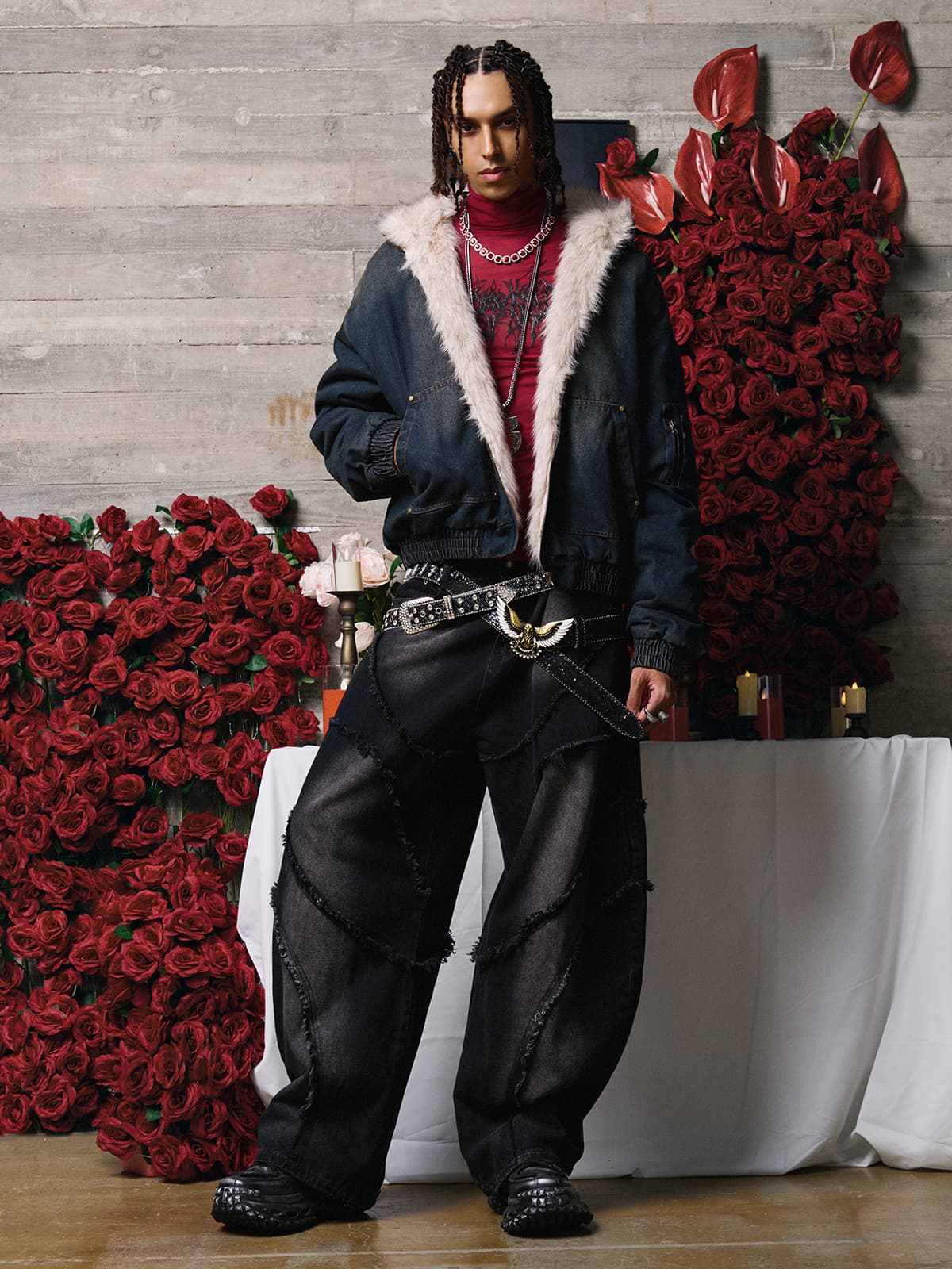 Young male model in a Distressed Washed Faux Fur Winter Jacket, showcasing its rugged texture and faux-fur lining, surrounded by candles and red roses.