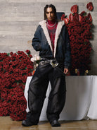 Young male model in a Distressed Washed Faux Fur Winter Jacket, showcasing its rugged texture and faux-fur lining, surrounded by candles and red roses.