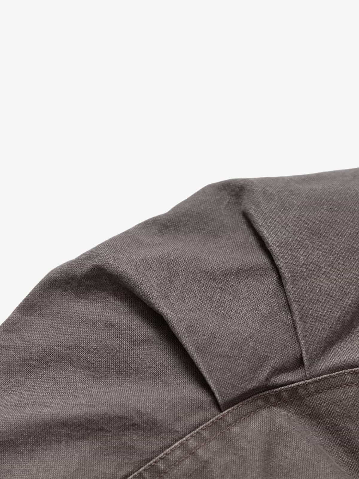 Close-up of the Graphic Graffiti High Neck Street Jacket, showcasing dark gray woven fabric with stitching and a pleat, highlighting its edgy streetwear style.