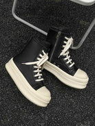 High-Top Platform Streetwear Sneakers featuring black high-top design with off-white chunky soles and laces, showcased on a rough asphalt surface for a bold, modern aesthetic.