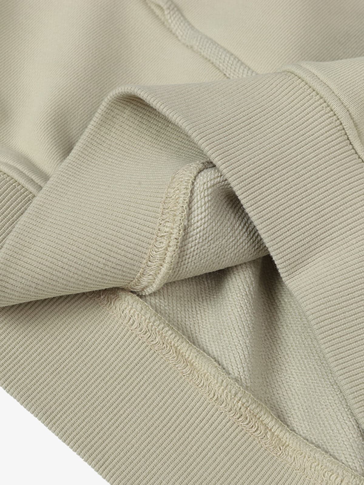 Close-up of the Ink Dyed Raw-Edge Streetwear Hoodie's ribbed knit cuff, showcasing overlock stitching and raw-edge detailing for an authentic streetwear vibe.