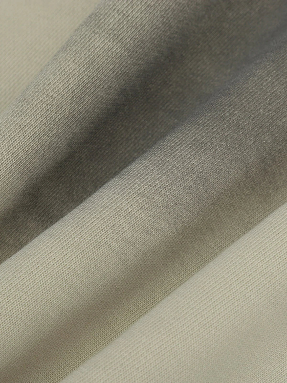 Close-up of Ink Dyed Raw-Edge Streetwear Hoodie showcasing its neutral-toned, woven fabric with visible texture, ink-dyed fading, and raw-edge detailing for an oversized, rugged look.
