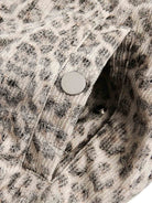Close-up of Leopard Faux Fur Hooded Jacket fabric, showing muted animal print and silvery snap-button, hinting at the garment's stylish, textured design.
