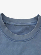 Close-up of Retro Graphic Layered Streetwear T-Shirt's ribbed neckline, showcasing stitching details, highlighting the layered design and vintage streetwear aesthetic.