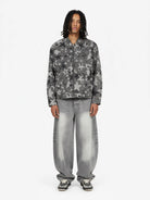 Model in Retro Washed Grey Baggy Jeans with star print denim jacket, showcasing wide, faded silhouette and chunky sneakers, embodying vintage streetwear style.