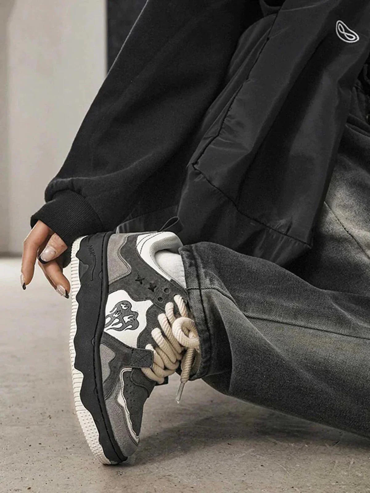 Vintage Chunky Graphic Skate Shoes with flame-like motifs, thick rope laces, and a low-top silhouette, paired with cuffed grey jeans and white socks.