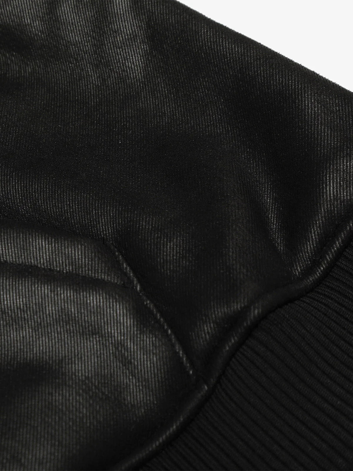 Close-up of the Vintage Hooded Leather-Look Street Jacket, showcasing its leather-look finish, ribbed cuff, and stitched seam, highlighting its bomber-style sleeve design.