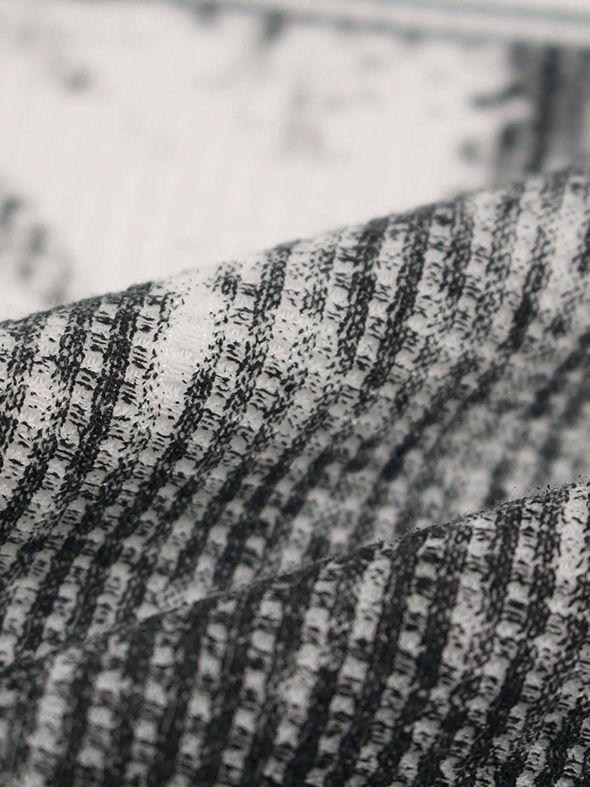 Close-up of textured black-and-white striped fabric from the Vintage Waffle Graphic Long-Sleeve T-Shirt, showcasing its unique knit pattern and retro streetwear vibe.