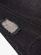 Close-up of Vintage Washed Baggy Ripped Jeans showing a distressed patch with frayed edges, revealing lighter threads, highlighting their grunge-inspired, oversized streetwear design.