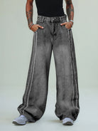 Model wearing Washed Distressed Raw-Edge Baggy Jeans with exposed seams, oversized fit, and pooling hems over light-gray sneakers. Hands in pockets, showcasing streetwear style.