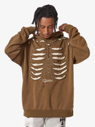 Model in a Washed Skeleton Graphic Streetwear Hoodie, featuring a rib-cage motif with cut-outs, adjusting hood; embodies vintage streetwear with oversized fit.