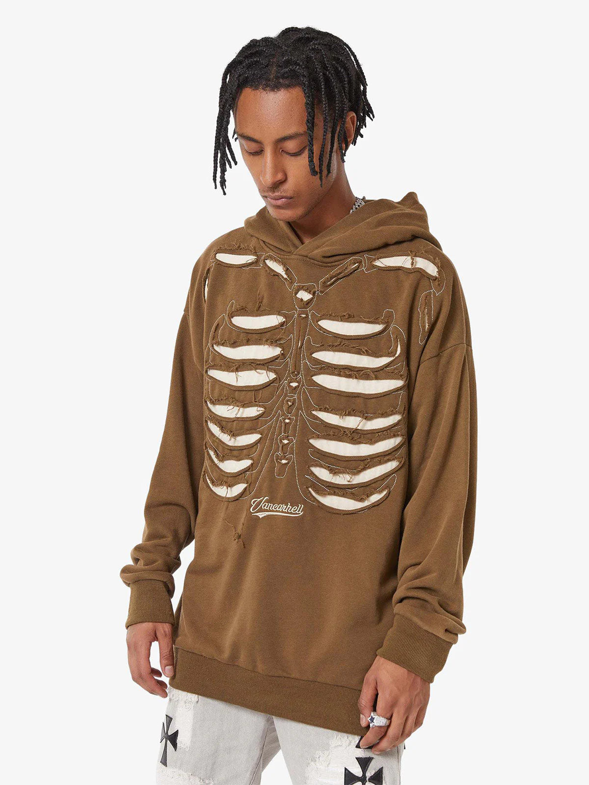 Young man wearing the Washed Skeleton Graphic Streetwear Hoodie, featuring oversized fit and ribcage appliqué, paired with light-washed pants and accessories.